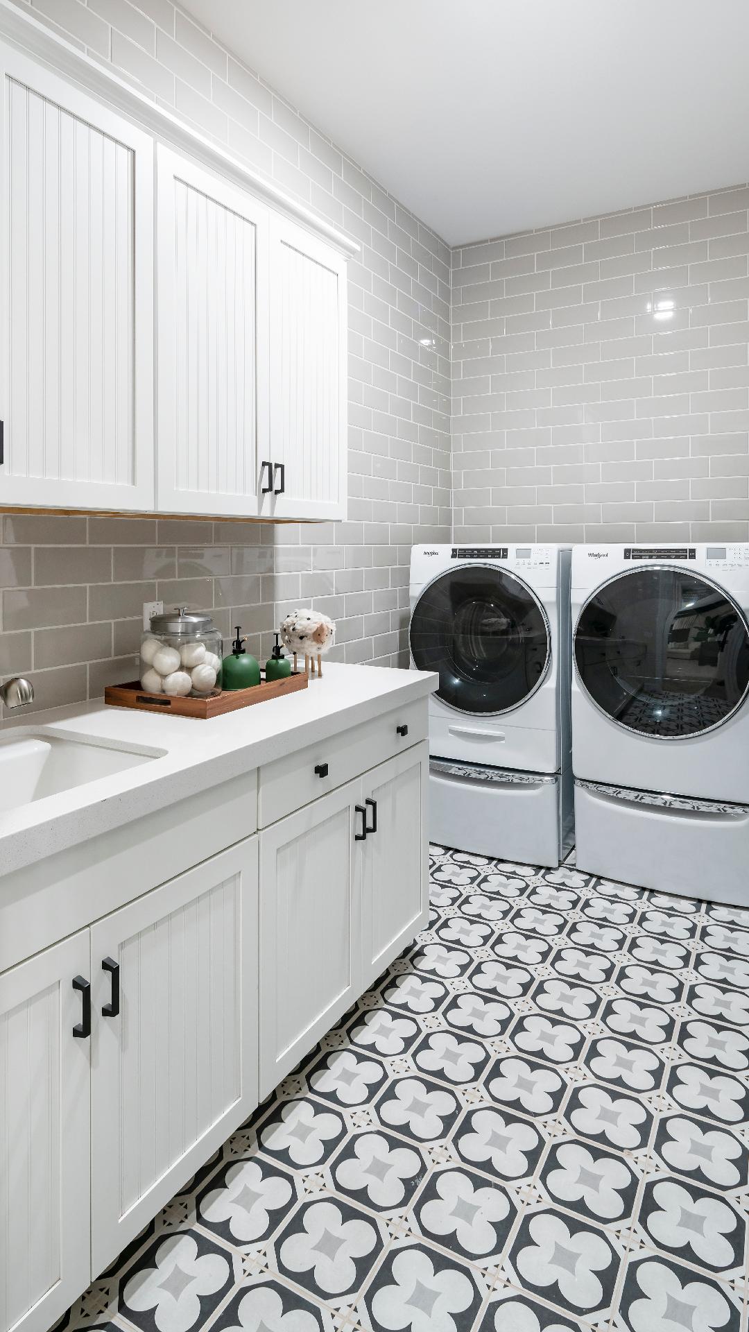 Laundry room with white cabinets, subway tile, quartz countertops and single basin sink